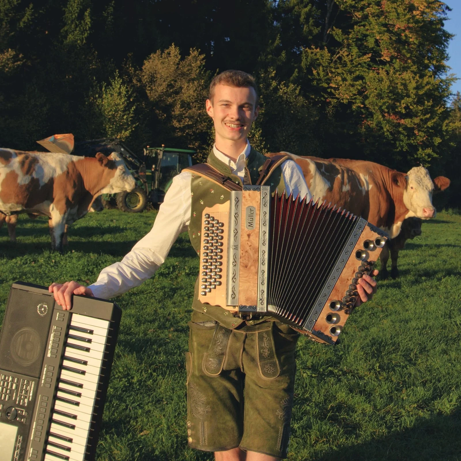 Elias mit der Steirischen und dem Keyboard auf der Weide